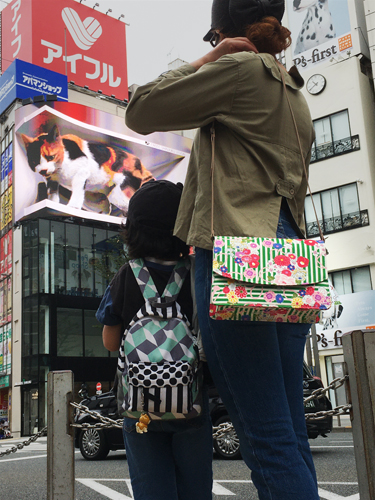 Saori Mochizuki（サオリモチヅキ／望月沙織）の和風花柄ショルダーバッグと新宿の猫の3Dデジタルサイネージ